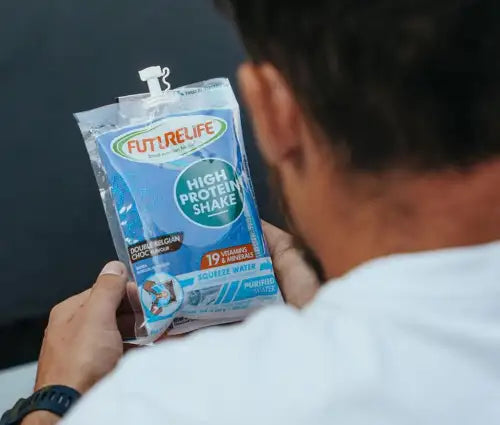 A blue and white futurelife high protein shake pouch with a pump dispenser, labeled ’double belgian chocolate’ flavor.