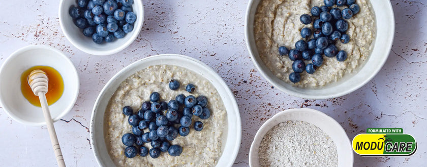 Blueberry oatmeal bowl set with honey dipper and fresh berries.