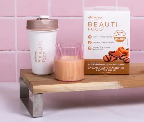 Caramel latte flavored protein shake with collagen, in a white and gold shaker cup.