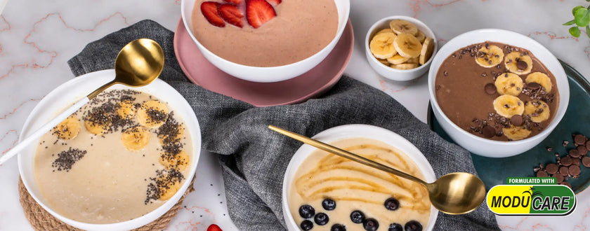 Chocolate banana smoothie bowl with golden spoons and blueberries as garnish.