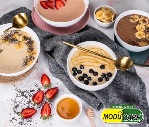 Chocolate banana smoothie bowl with honey drizzle and blueberries, white ceramic bowls.moducare