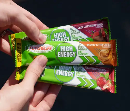 Green and orange wrapped futurelife high energy bars held in a hand.