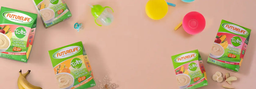 Green and pink futurelife tots baby food boxes with colorful fruit illustrations.