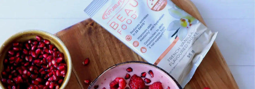 Pink smoothie bowl with raspberries and pomegranate seeds, topped with a packet of beautyfocus protein powder.