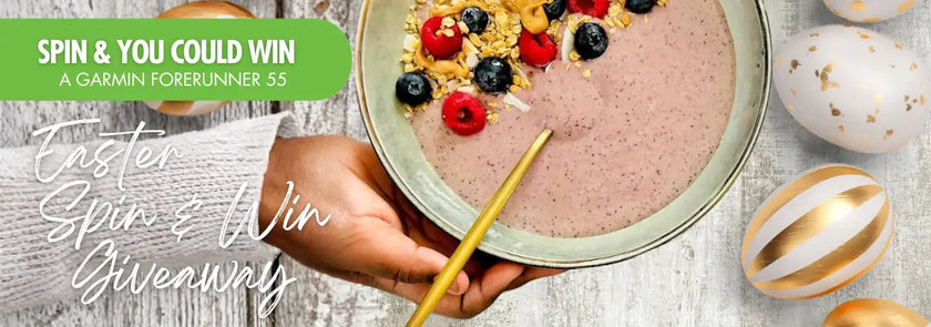 A pink smoothie bowl topped with mixed berries and granola, served in a light green ceramic dish.
