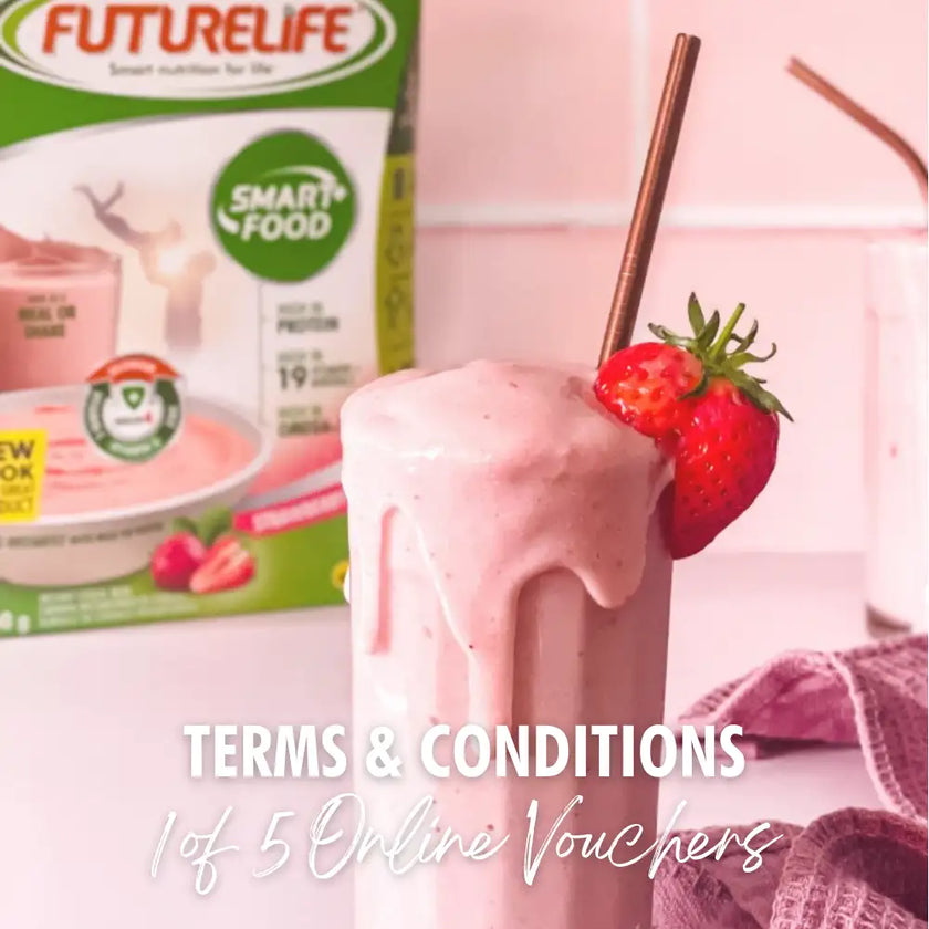 Pink strawberry smoothie in a clear glass with a copper straw and fresh strawberry garnish.