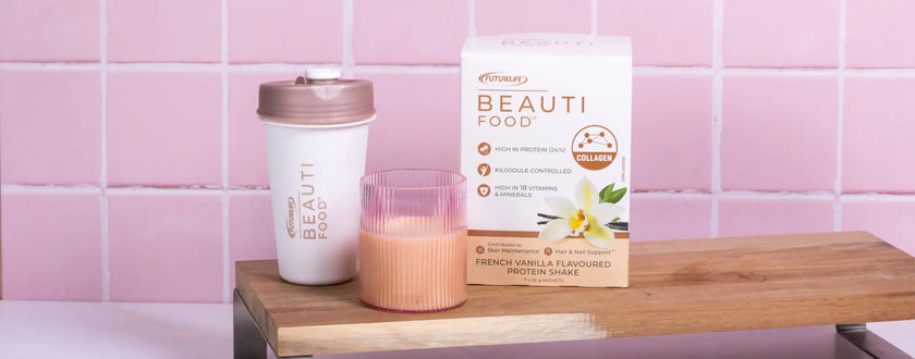 Pink and white floral candle with a wooden wick, encased in clear glass.