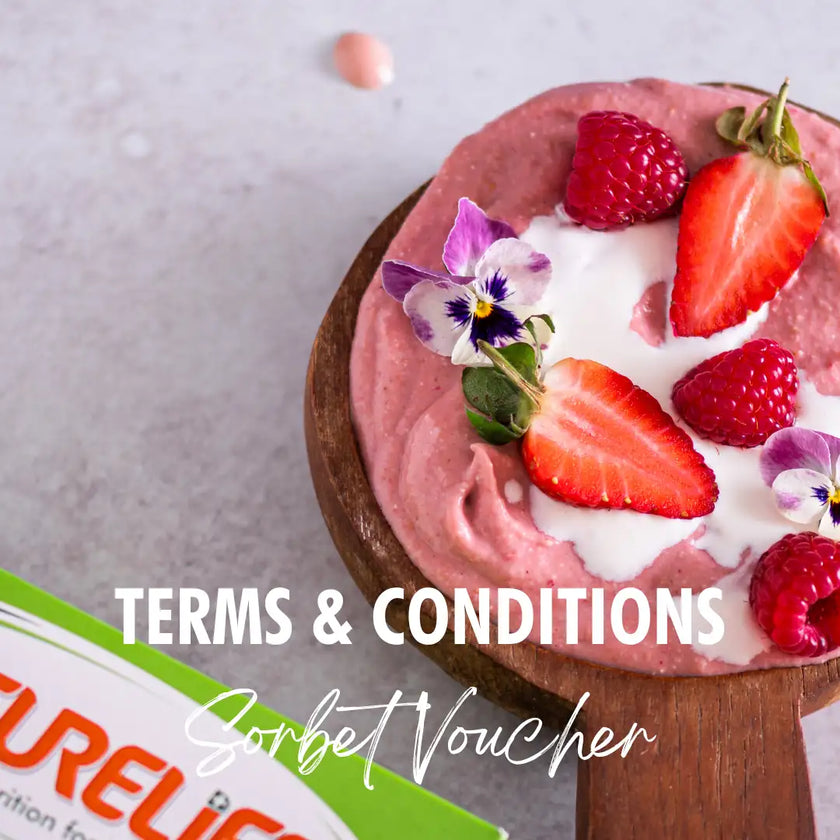 Strawberry sorbet with fresh berries and edible flowers on a wooden spoon.
