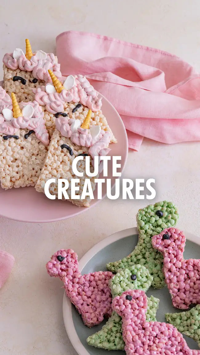Unicorn-shaped rice crispy treats with pink and white icing, gold horn, and marshmallow eyes.