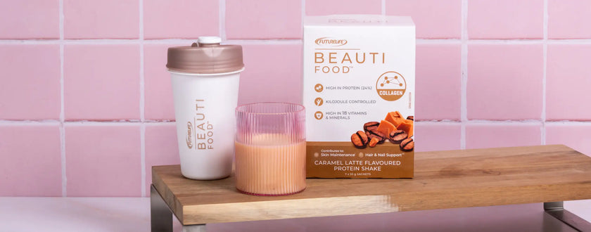 White and gold reusable coffee cup with a lid, featuring the ’beauti’ logo.