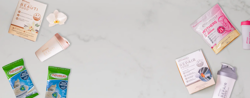 White orchid flower with green leaves and pink accents on a marble surface.